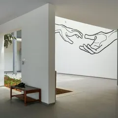 A wall mural at the KIPCER lobby, interpreting the theme of giving and receiving care. This artwork, depicting two hands reaching for each other, serves as a focal point and reinforces the hospice's mission.