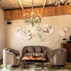 A wide shot of the hand painted flora and fauna canvases at Cafe Tesu in Delhi. This collection of round canvases was designed as a unique wall installation, bringing a touch of nature and elegance to the cafe's seating area.