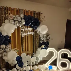 I also do modern and elegant setups for adult birthdays. This 26th birthday features a stylish navy blue, silver, and white balloon ring, a custom neon sign, and large illuminated marquee numbers.
