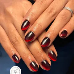 A striking black and red ombre cat-eye effect. The magnetic polish is manipulated to create a smooth transition from deep black to a fiery red tip.