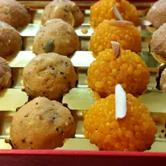 Our festive ladoos are a sight to behold. This box, prepared for a Karva Chauth sargi order, contains delicate motichoor ladoos garnished with almond slivers and seeded panjiri ladoos for energy.