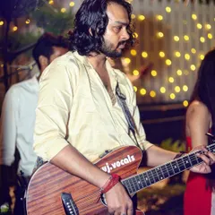 Live music adds so much to an event's atmosphere. This photo captures a guitarist mid-performance at a party, with the warm background lights creating a perfect stage-like setting.