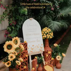 Little hues of Haldi to kickstart the celebrations. For Ketaki and Rakesh, we designed this rustic and sunny entrance decor using terracotta bricks, sunflowers, and a custom welcome sign to set a warm and inviting tone.