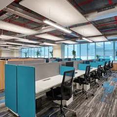 A linear workstation arrangement in a large open office. We used suspended acoustic panels and linear lighting to manage noise and provide consistent, comfortable illumination across the floor.