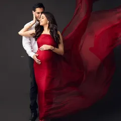 Let's create some magic. For this dramatic maternity portrait, we used a flowing red fabric against a dark backdrop to create a powerful and artistic image that celebrates the beauty of pregnancy. This is for the mamma who wants to feel like a star.
