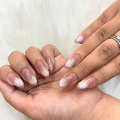 A subtle and sophisticated glitter ombre on almond-shaped nails. The glitter is concentrated at the tips and fades softly towards the base, creating a delicate, sparkling effect.