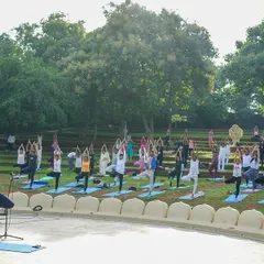 A large group of people practice yoga in our outdoor amphitheater during the 10th International Day of Yoga. The serene, natural surroundings enhance the experience of connecting with oneself.