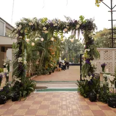 This pre-wedding gala entrance defined minimalist elegance. A lush floral archway made of greenery and deep purple flowers created a sophisticated and welcoming path for guests.
