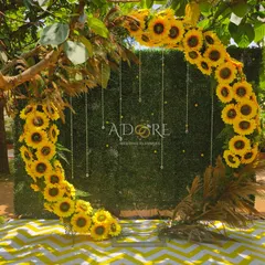 A perfect photo spot for a sunflower-themed event. This circular selfie booth, adorned with bright sunflowers and delicate hanging crystals against a green hedge, was a huge hit with guests.