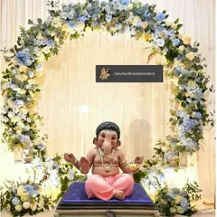 For a modern Ganesh Chaturthi celebration, I designed this serene circular arch using a mix of blue and white flowers. This setup creates a peaceful and beautiful focal point for your Ganpati idol at home.