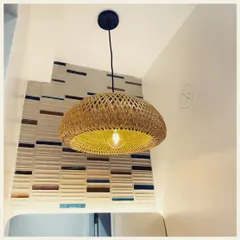 A simple yet beautiful woven pendant light, this fixture adds a touch of boho elegance to this corner. Its warm glow highlights the textured wallpaper behind it, creating a cozy and inviting atmosphere.
