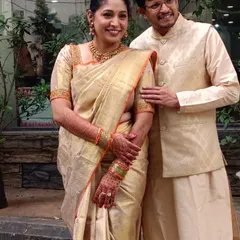 A candid photo of Geeta and her husband. The golden tissue silk saree radiates a timeless charm, perfect for wedding festivities.