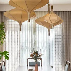 These sculptural pendant lights hang above a dining table, acting as a stunning centerpiece. Their organic shape and soft glow create an intimate atmosphere for meals.