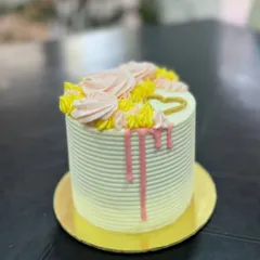 A mini drip cake with piped roses, perfect for one or two people.