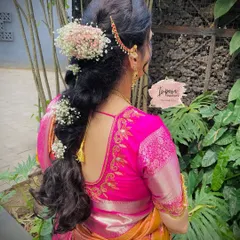 A soft and romantic messy braid for a Muhurtham look. This style uses baby's breath and a delicate hair accessory, perfect for a bride who wants something unique yet traditional.