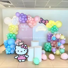 A classic Hello Kitty theme for a third birthday, featuring a character cutout, custom backdrops, and a pastel rainbow balloon arrangement. The setup is completed with a balloon-filled marquee number '3'.