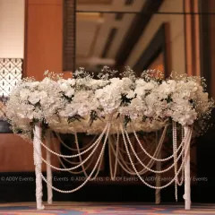 A statement piece for the Nikah ceremony. This signing table is completely covered in white hydrangeas and baby's breath, with elegant pearl strings cascading down the sides.