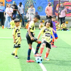 A young player practices ball control under the watchful eye of her teammate and the parents on the sidelines. Our training sessions are a community event.