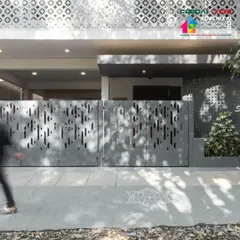 The entrance gate of the '10x10 Residence', where modern perforated patterns meet a traditional Rangoli motif etched into the ground, a detail noted in our award submission.