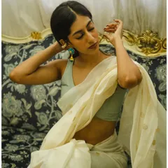 An intimate and delicate pose, focusing on the details of the jewelry and the soft expression of the model.