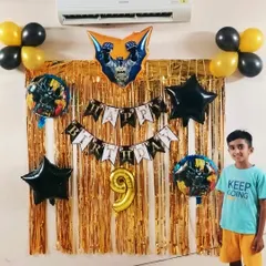 For a young fan of the Dark Knight, we put together this awesome Batman-themed birthday decoration. The setup includes a gold shimmer curtain, a Batman banner, and character-themed foil balloons.