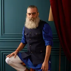 We love to layer. Here, a navy blue safari-style vest is worn over a royal blue kurta and white Jodhpuri pants for a contemporary yet traditional look.