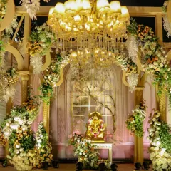 For a divine and opulent ceremony, I framed the sacred space with grand arches overflowing with white and gold florals. A magnificent chandelier and a central Ganesha idol add blessings and grandeur to the setting.