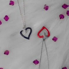 A simple and clean product shot of two heart-shaped necklaces. The fluffy white background and scattered purple gems create a playful and romantic feel, perfect for marketing these accessories.