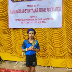 Ghanavi proudly holds her trophy after a successful tournament organized by the Vijayanagara District Table Tennis Association. Her focus and hard work are truly paying off.