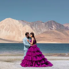 An intimate moment of connection amidst the grand landscape of Leh. The contrast between the soft blue suit and the vibrant purple gown adds a touch of high fashion to this stunning natural setting.
