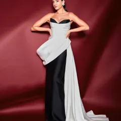 A classic black and white gown with a modern twist. The architectural drape and strapless corset create a sophisticated and timeless red carpet look that is both elegant and powerful.