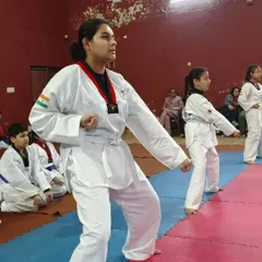 A senior student demonstrates a strong, focused stance during Taekwondo practice. Her posture and concentration show the discipline and mental stillness we cultivate in our classes.
