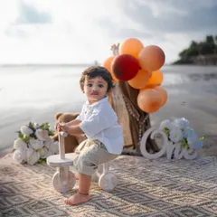 This little one looks so charming posing on his tricycle during his golden hour beach shoot. The warm light creates a magical glow.