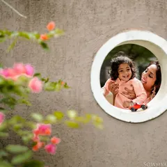 A creative and playful portrait of a mother and child seen through a circular window. We love using architectural elements to frame our subjects and add a unique, artistic touch to your family photos.