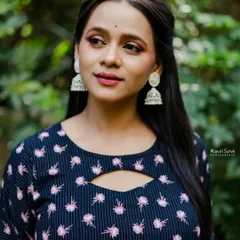 A beautiful close-up headshot for a celebrity portfolio. The soft outdoor lighting highlights her features and the elegant silver jhumkas, creating a classic and appealing look.