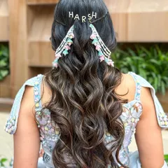 I love adding personal touches. This hairstyle for a pre-wedding event features a custom clip with the groom's name, "Harsh," making it extra special.