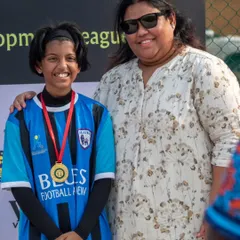 A young player proudly wears her medal after being recognized for an outstanding performance. We believe in celebrating every achievement.