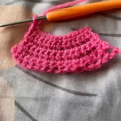 This piece shows a student practicing how to increase stitches to create a curved shape. This is a fundamental skill for making everything from hats to amigurumi toys.