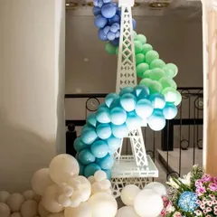 A stylish Eiffel Tower prop decorated with a cascading balloon garland in shades of blue, green, and white. This was a standout piece from our chic Parisian-themed baby shower, adding a touch of French flair.