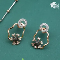 A close-up of the Eclipse Glow earrings. Notice the contrast between the sparkling white diamond halo and the dramatic black diamond center, set within an abstract rose gold frame.