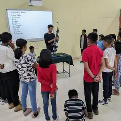 I always begin my workshops with a thorough safety briefing. Here, I am demonstrating the parts of an air rifle to a group of young learners before we head to the shooting line.