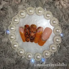 A full set inspired by the leopard, featuring a 3D portrait nail, leopard print, and sparkling orange glitter nails with crystal accents.