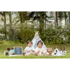 This pre-birthday shoot for twins Avyaan and Aanshi shows a complete themed setup in an outdoor park. I provide all the props, including the teepee, signage, and teddy bear, to create a magical setting for your child's milestone photos.