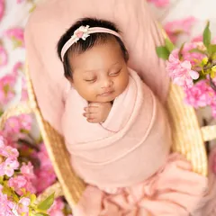 This newborn is nestled in a basket, surrounded by beautiful pink blossoms. I love incorporating floral elements to add a touch of nature and softness to the portraits.