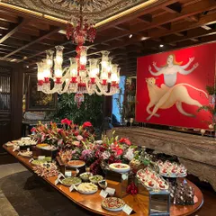 A magnificent, full-length grazing table in a grand room, showcasing our ability to cater to large, upscale events. The spread includes a wide variety of dishes, from savory platters to desserts, all artfully arranged to impress guests.