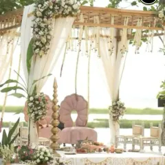 A beautiful rustic mandap with delicate floral arrangements and flowing drapes, perfectly suited for a serene waterside wedding ceremony.