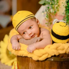 Our sweet little honeybee. This newborn is wide-eyed and curious in a charming bumblebee-themed setup with soft, yellow textures.