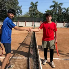 Sportsmanship is a core value we teach. Two players shake hands at the net after a competitive match during our 2025 Round Robin Tennis Tournament.