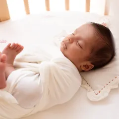Another beautiful angle of the baby sleeping in their crib. The soft, natural light from the window creates a serene and timeless portrait.