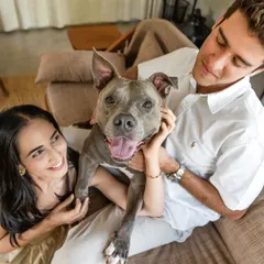 A beautiful portrait of an engaged couple holding their beloved pitbull, Millie. Her happy, smiling face shows she's just as excited about the celebration as they are.